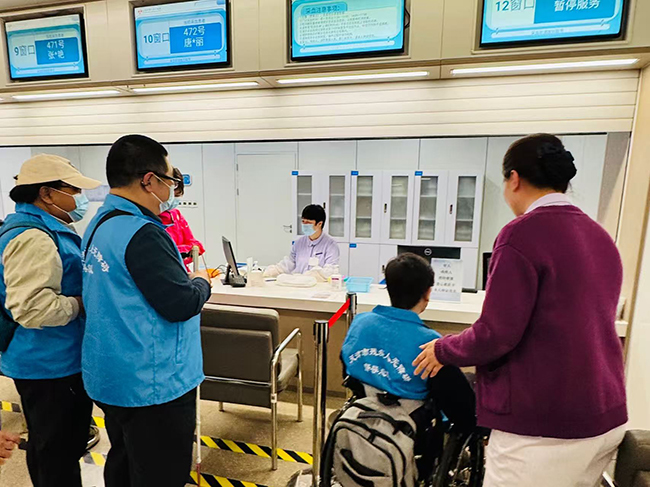 图为督导队员在体验低位采血窗口